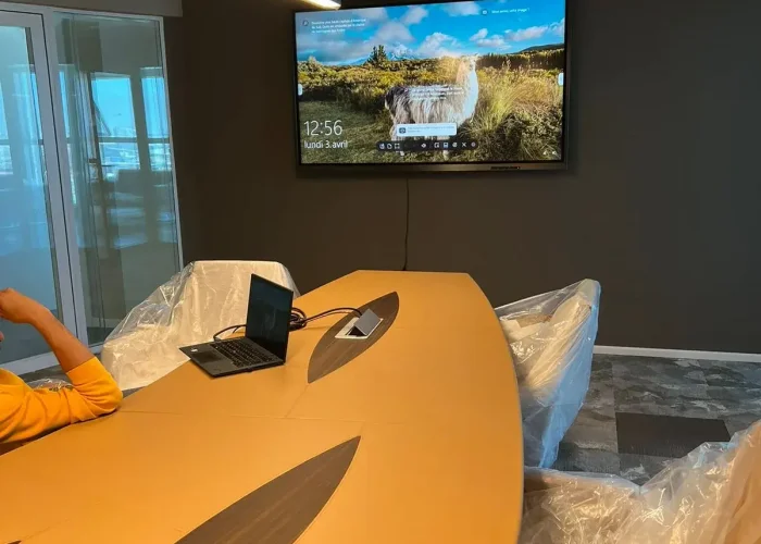 Salle de réunion avec écran interactif et équipements audiovisuels professionnels